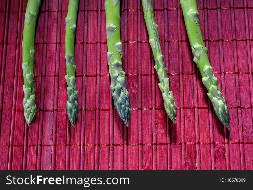 Fresh asparagus on a red mat