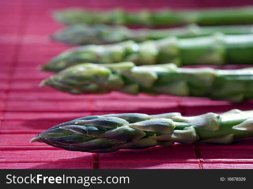 Fresh asparagus on a red mat