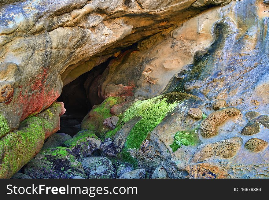 A small dry sea cave. Large rocks with moss. Photograph originally taken on the Oregon coast. A small dry sea cave. Large rocks with moss. Photograph originally taken on the Oregon coast.