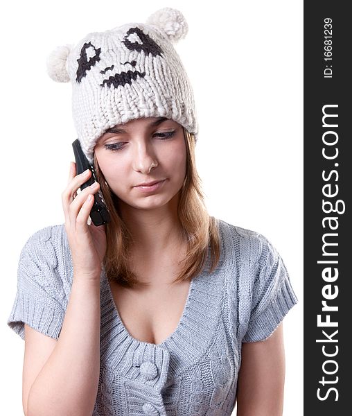 Beautiful girl in winter hat with telephone on white background