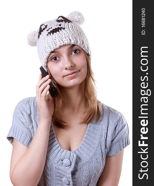 Beautiful girl in winter hat with telephone on white background