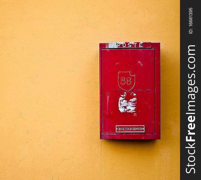 Photo of a red postal box on a yellow wall. Photo of a red postal box on a yellow wall