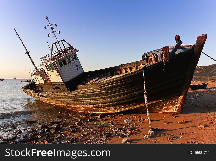 A fishing vessel lay at anchor in the bay