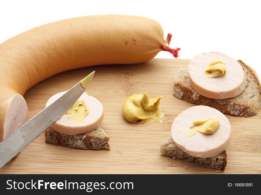 Meat sausage in pieces and with mustard