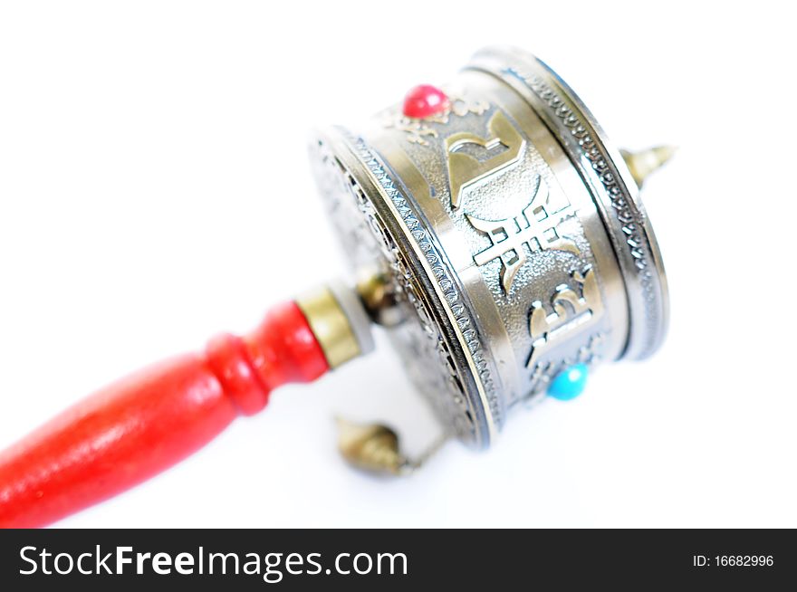 Close-up view of a Tibetan prayer wheel isolated on white background.
