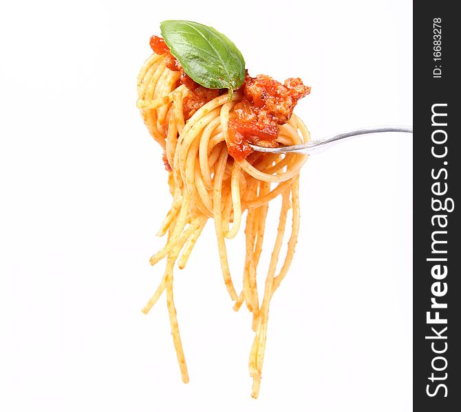 Spaghetti with sauce bolognese hanging on a fork decorated with fresh basil. Spaghetti with sauce bolognese hanging on a fork decorated with fresh basil