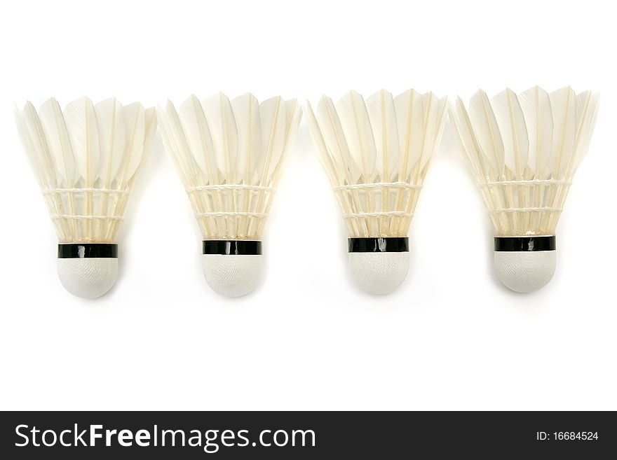 Four white badminton shuttlecocks on white background