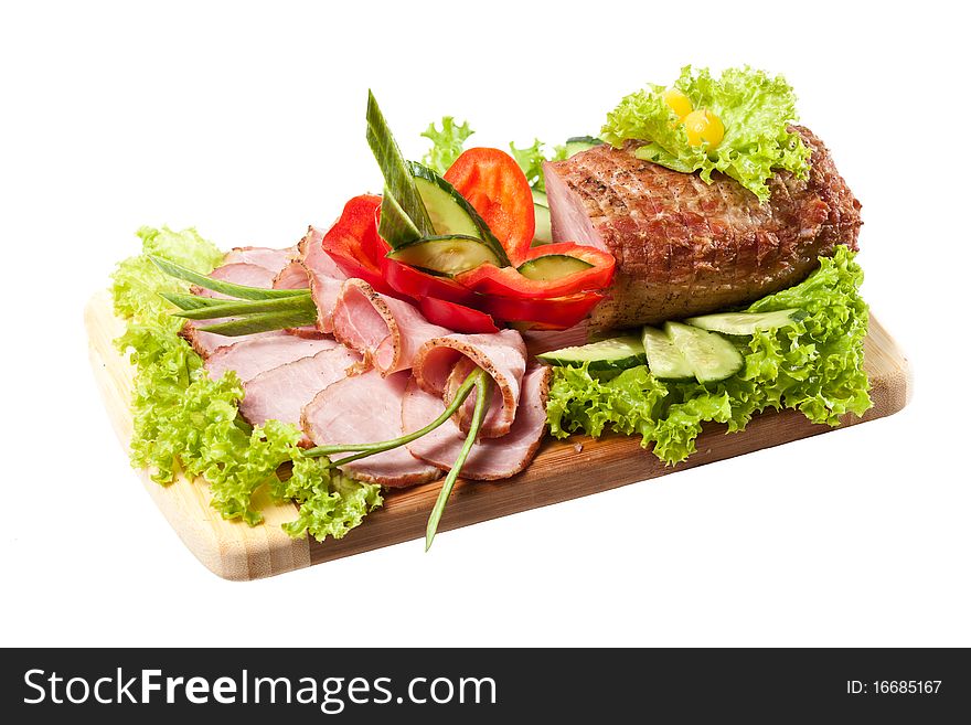 Whole Baked Ham on a cutting board decorated vegetables and herbs on white background