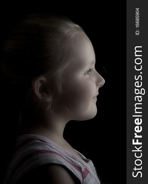 Side portrait of young girl on black background. Side portrait of young girl on black background