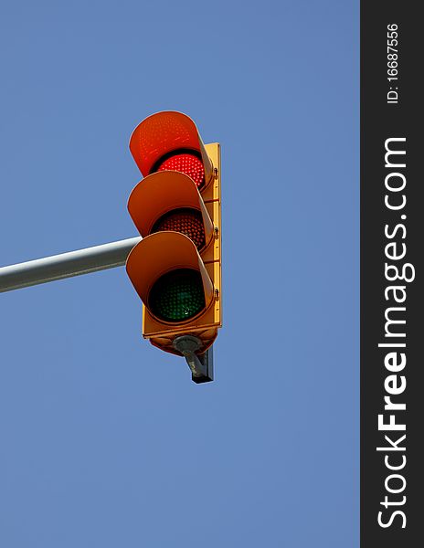 Red signal of a traffic light. Against the blue sky. Red signal of a traffic light. Against the blue sky.