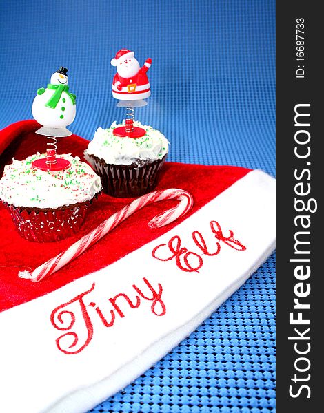 Santa hat with two cupcakes decorated for Christmas and candy cane. Santa hat with two cupcakes decorated for Christmas and candy cane