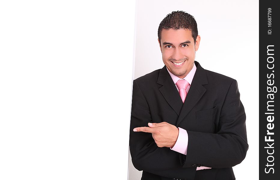 Young businessman in suit smiling and pointing copy space