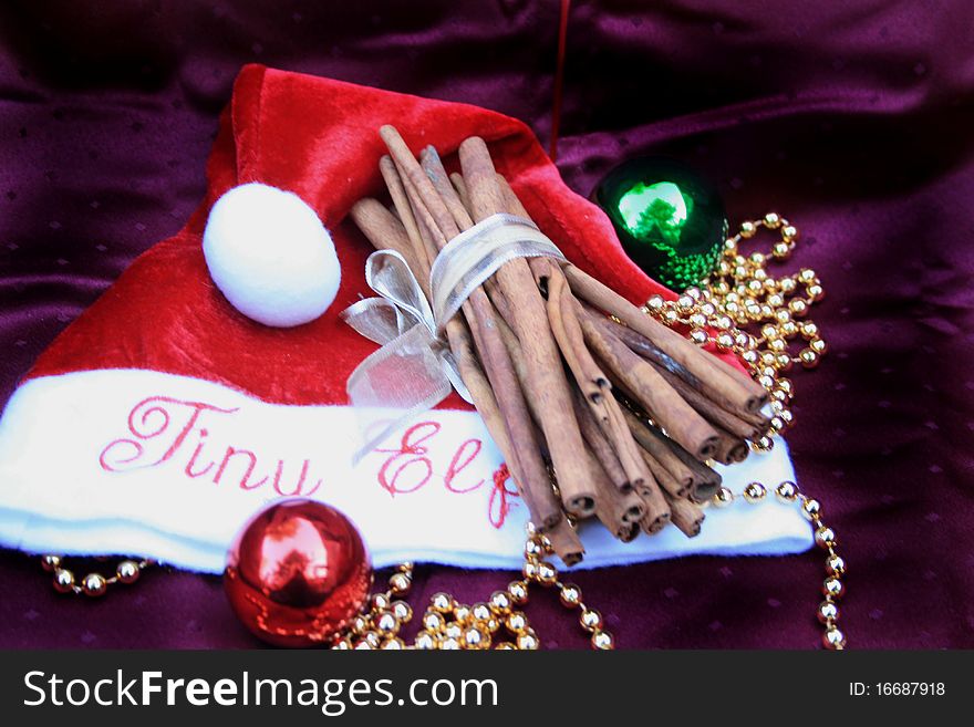 Christmas elf hat with stack of cinnamon sticks and ornaments. Christmas elf hat with stack of cinnamon sticks and ornaments