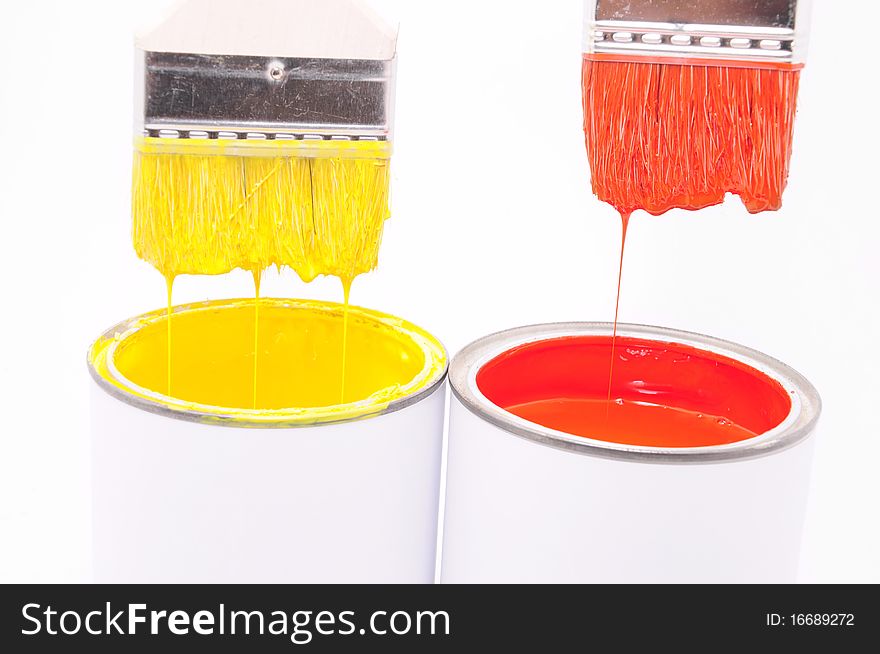 Yellow and red colors in buckets and brushes for painting. Yellow and red colors in buckets and brushes for painting