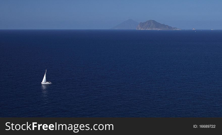 Yacht sailing among Eolian islands Lipari and Panarea. Stromboli in the background. Yacht sailing among Eolian islands Lipari and Panarea. Stromboli in the background.