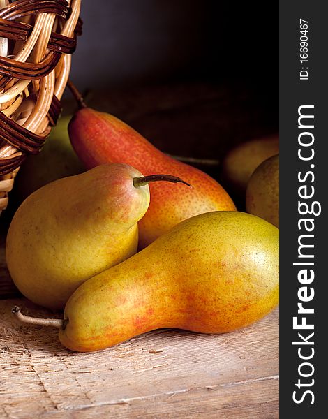 Pears on a wooden table and a basket