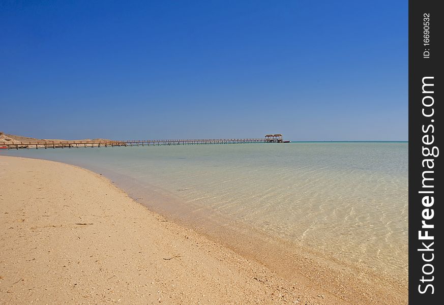 View from a tropical beach with a small wooden jetty. View from a tropical beach with a small wooden jetty