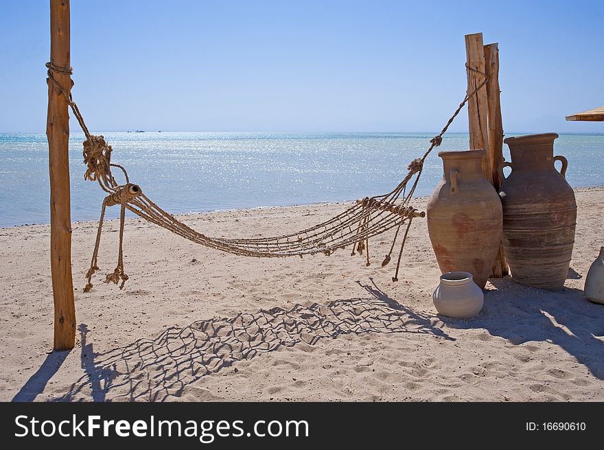 A rope hammock on a tropical beach