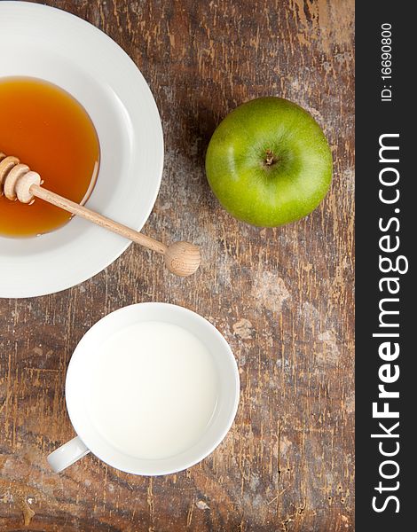 Breakfast with milk, honey and apple on the old wooden table