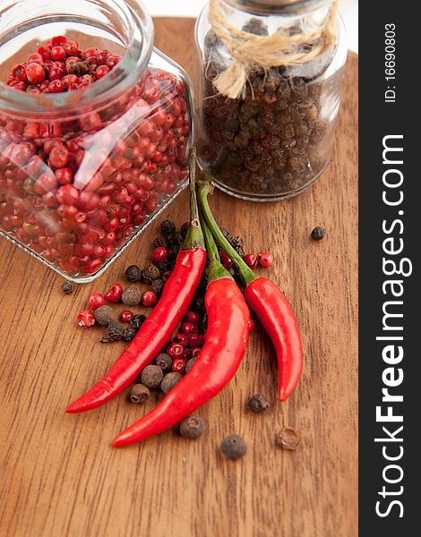 Red chili pepper and pepper's mix on the wooden desk