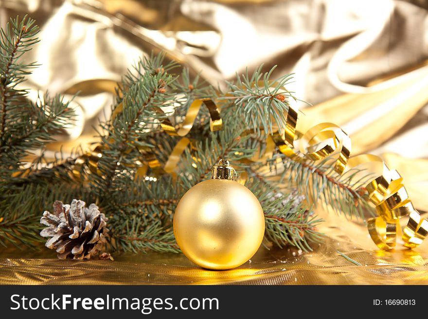 Golden christmas ball and cone with christmas tree on the gold background