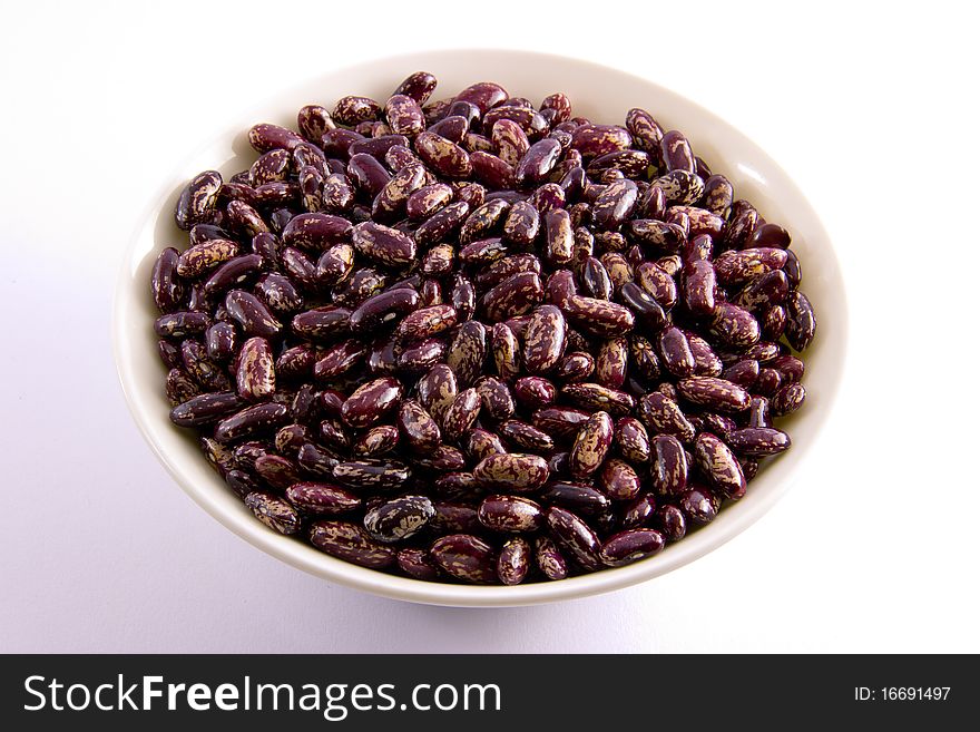 Bright red beans in white bowl on white table