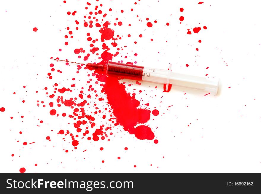 Syringe with a red liquid and stains isolated on white