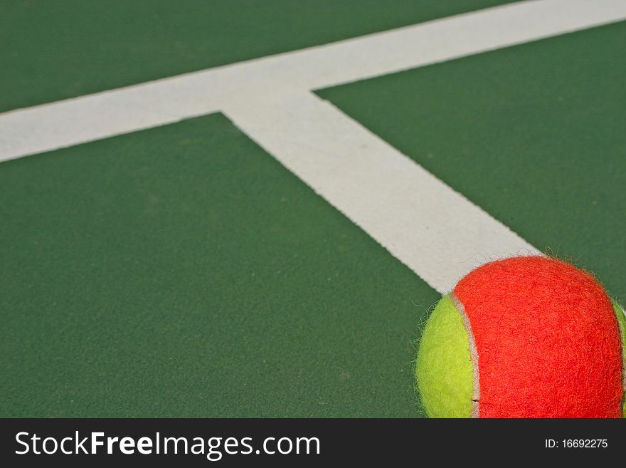 Yellow-red balls on a green tennis court. Yellow-red balls on a green tennis court