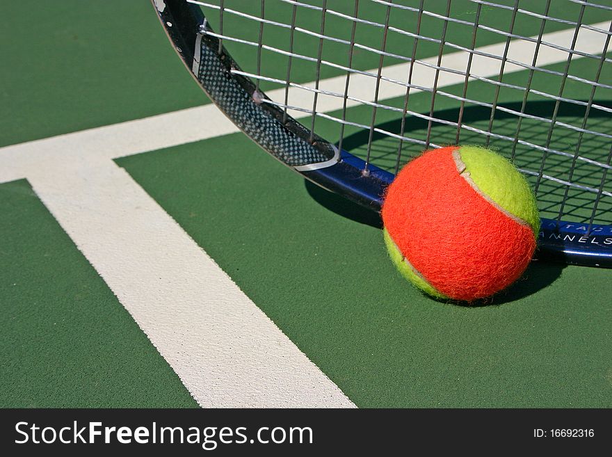 Yellow-red balls on a green tennis court. Yellow-red balls on a green tennis court