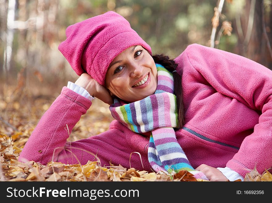 Horizontal image of a beautiful young woman lying in a pile of leaves. Horizontal image of a beautiful young woman lying in a pile of leaves.