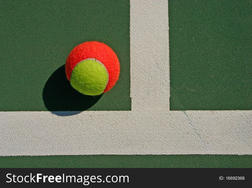 Yellow-red balls on a green tennis court. Yellow-red balls on a green tennis court