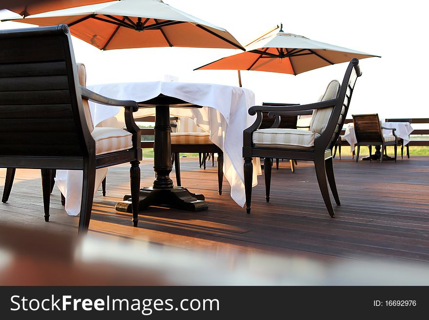 Table with white tablecloth and umbrellas outdoors. Table with white tablecloth and umbrellas outdoors
