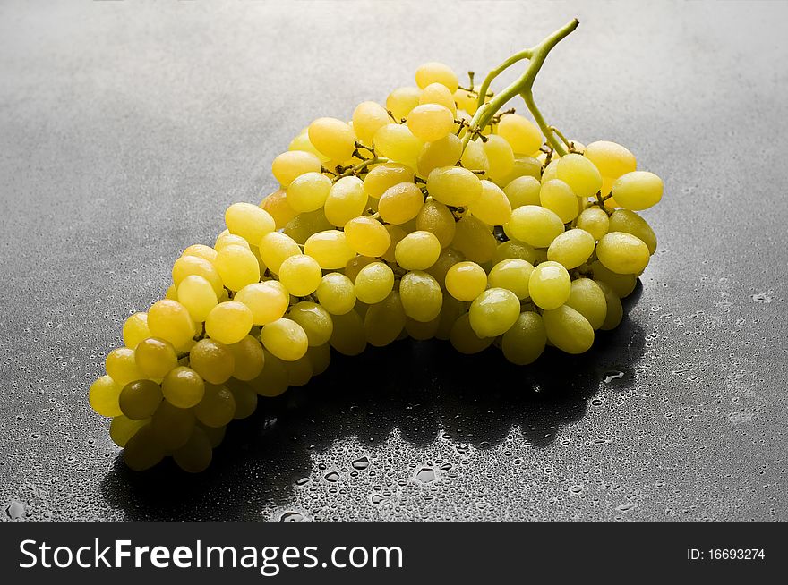 Bunch of fresh grapes on black glossy background