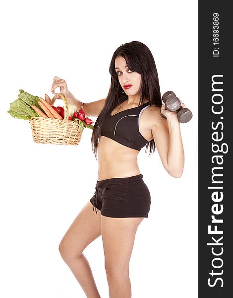 A woman is holding a basket of vegetables and some weights. A woman is holding a basket of vegetables and some weights.