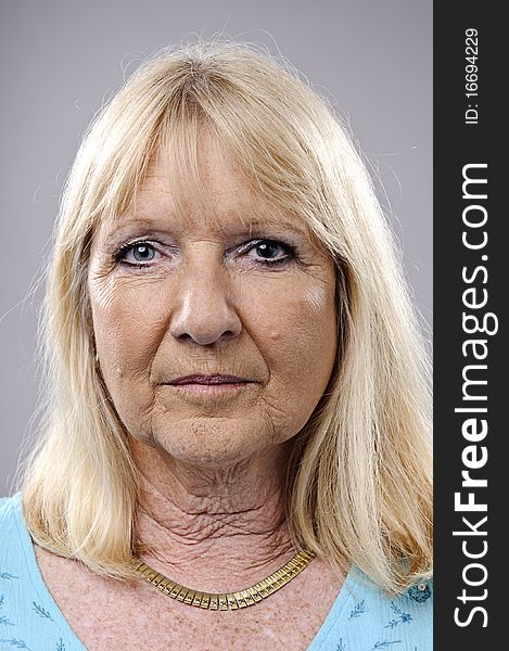 Wrinkled blonde woman poses for a portrait in studio. Wrinkled blonde woman poses for a portrait in studio