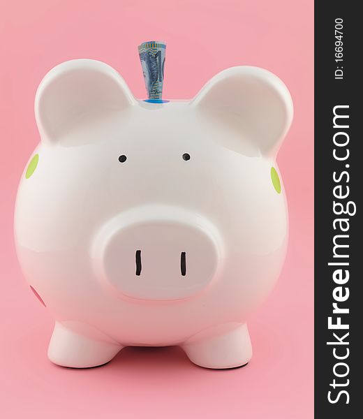 A piggy bank isolated against a pink background