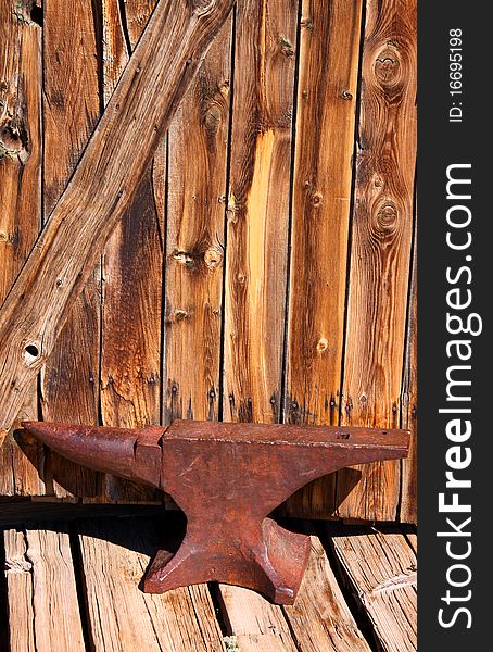 Old rustic Anvil with wooden wall background