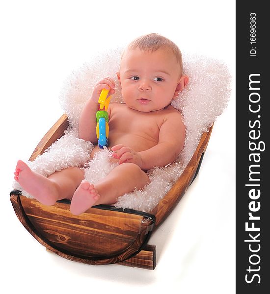 An adorable baby relaxing in a small fluff-lined half-barrel. He holds a toy in his hand. An adorable baby relaxing in a small fluff-lined half-barrel. He holds a toy in his hand.