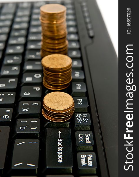 Line of coins on black computer keyboard. Line of coins on black computer keyboard
