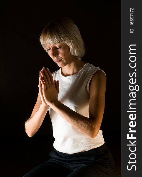 Woman praying on black background