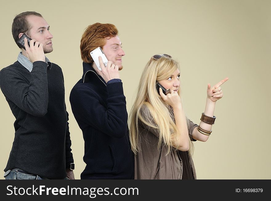 Two men and one woman calling by phone in office. Two men and one woman calling by phone in office