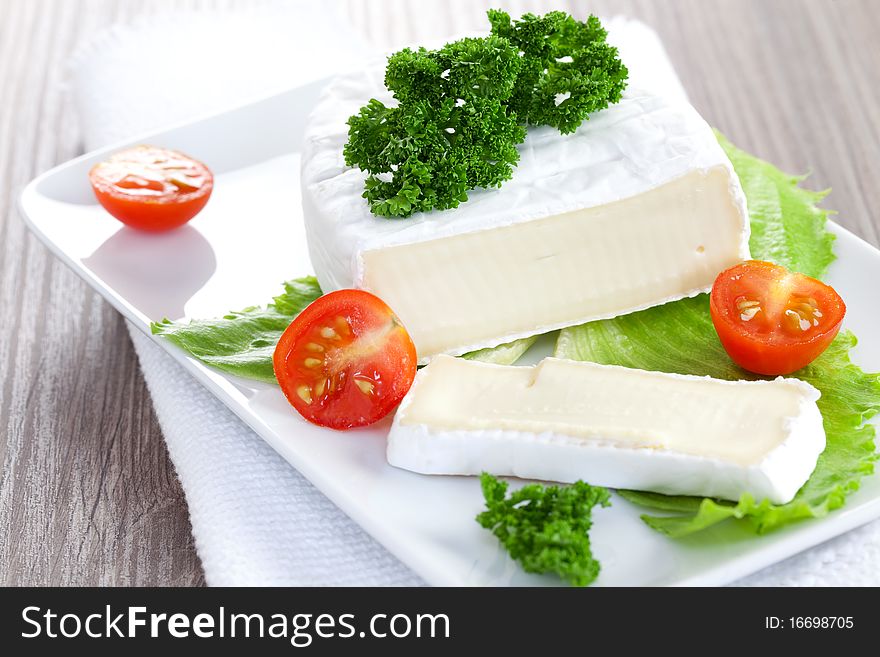 Camembert sliced on plate with tomato. Camembert sliced on plate with tomato