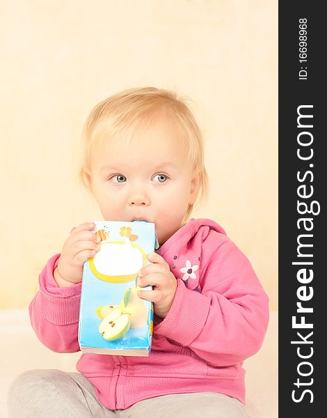 Cute toddler girl sit and drinking juice