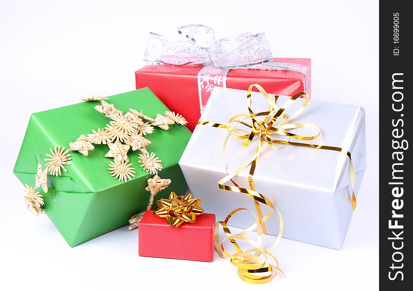 Gifts in silver, green and red wrapping with bows on white background. Gifts in silver, green and red wrapping with bows on white background