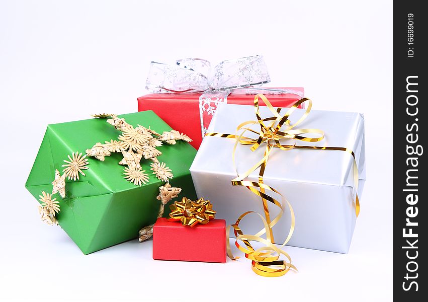 Gifts in silver, green and red wrapping with bows on white background. Gifts in silver, green and red wrapping with bows on white background