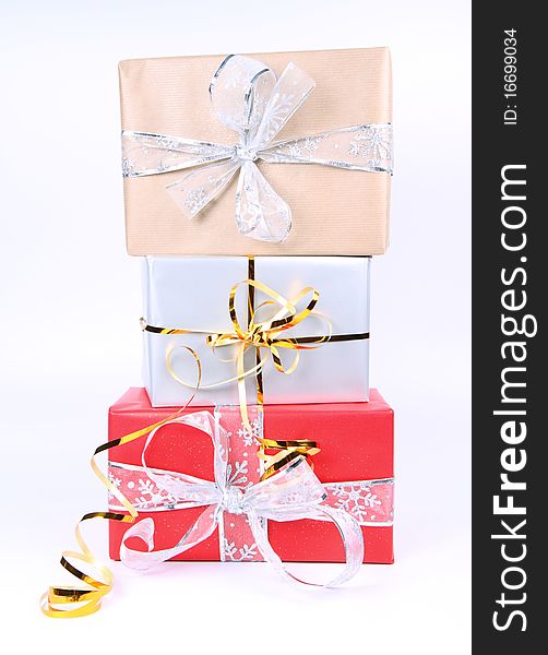 Gifts in silver, brown and red wrapping with bows on white background