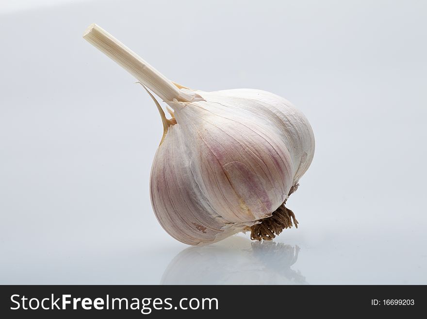 Clove garlic on a light gray background with a shadow, there is copyspace. Clove garlic on a light gray background with a shadow, there is copyspace