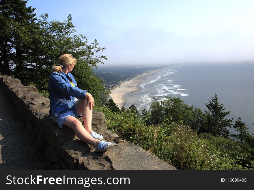 Sitting on a retaining wall and looking at the Oregon coastline on a foggy hazy day. Sitting on a retaining wall and looking at the Oregon coastline on a foggy hazy day.