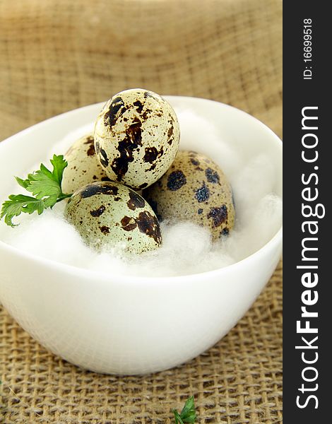 Quail egg in a white bowl on brown napkin