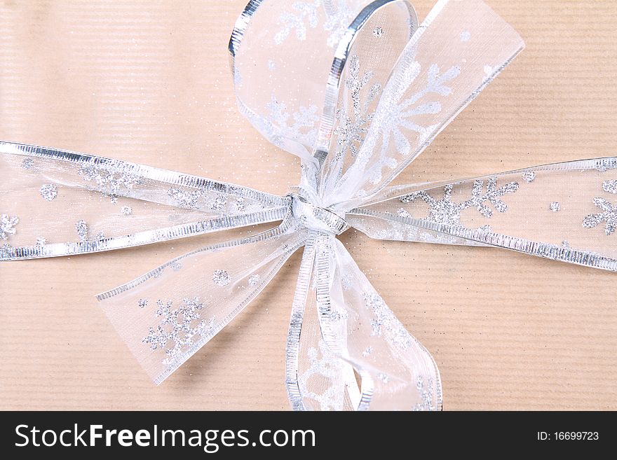 Gift in paper wrapping with silver bow in close up